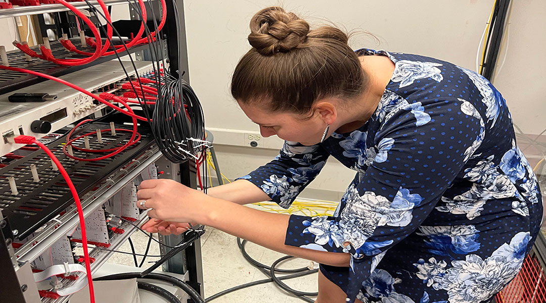 A photo of professor Kristen Booth fixing wires on a DC circuit in her electrical engineering lab at the University of South Carolina.