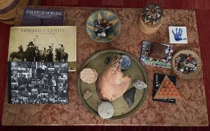 A photo of professor Virginia Johnson's living room table with artifacts from South Africa and books.
