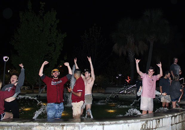 Students cheer in a fountain