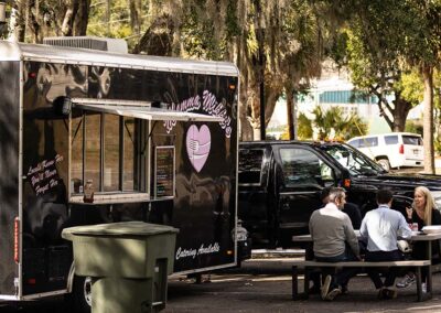 A group of journalists eat lunch outside of one of the many food trucks surrounding the court.
